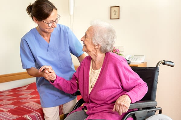 Staff member helping a resident at Heritage Senior Living and their signature programming. 