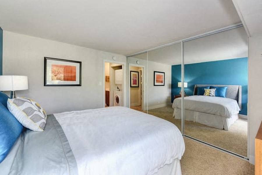 Cherry Chase Apartments for Rent - Citra - Spacious Bedroom With Plush Carpet Flooring, Sliding Mirror Closet Doors, And View Of In-Unit Washer And Dryer