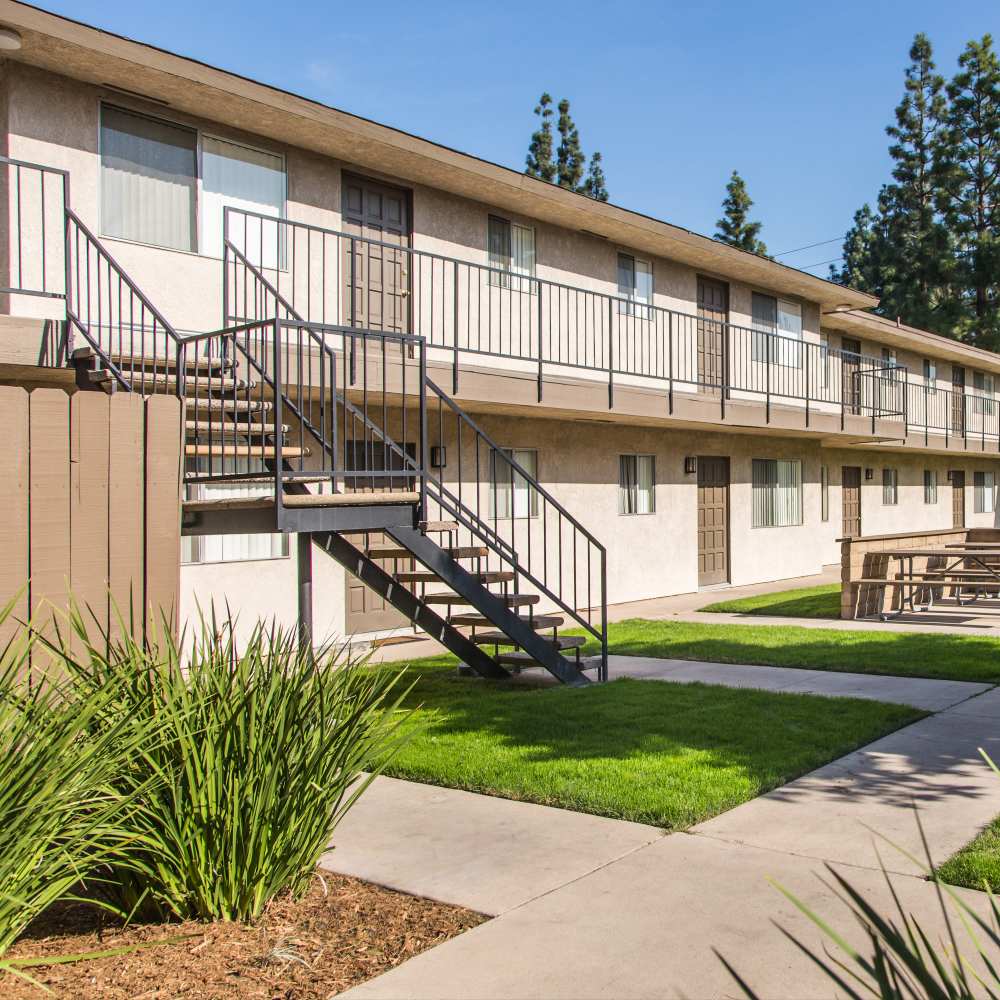 Beautifully landscaped garden with exterior shot of apartments at Orange Grove in Garden Grove, California