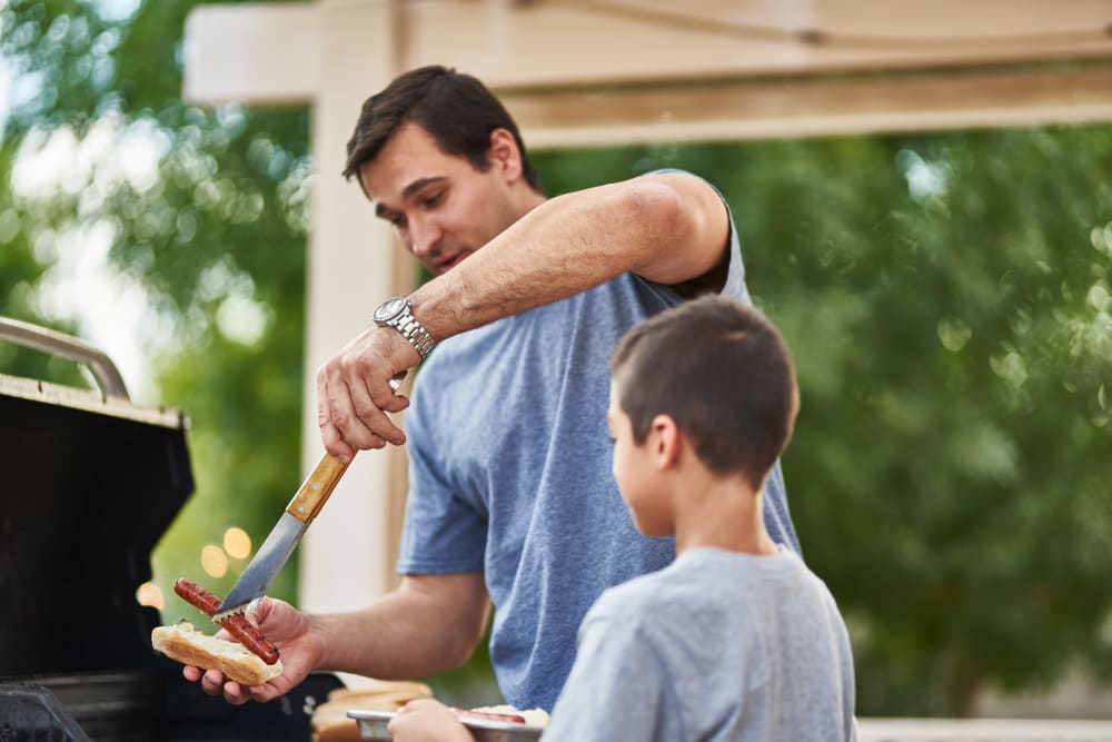 Father and son grilling outside at The Everstead at Windrose in Spring, Texas