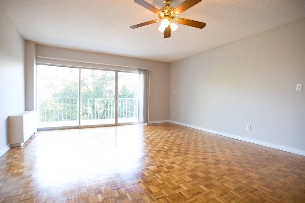 Spacious living area with stylish wood flooring and natural lighting at Central Gardens in Memphis, Tennessee