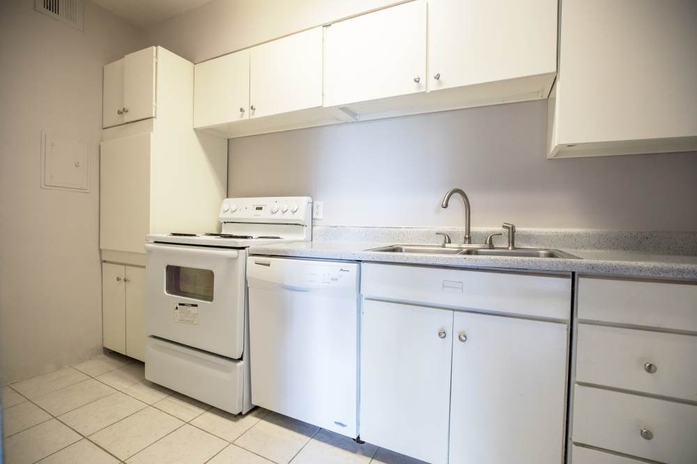 Kitchen with sleek white colored appliances and cabinetry at Central Gardens in Memphis, Tennessee