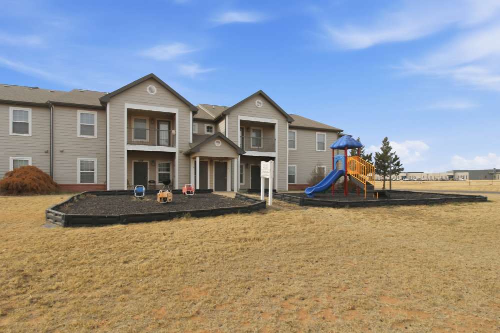 Community apartment exterior view with playground at Avalon Park in Brownfield, Texas