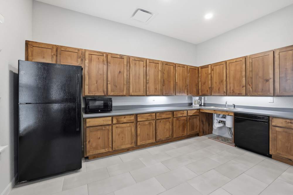 Modern kitchen with rich wooden cabinetry and sleek appliances at Flats At Sam Lane in Ringgold, Georgia.