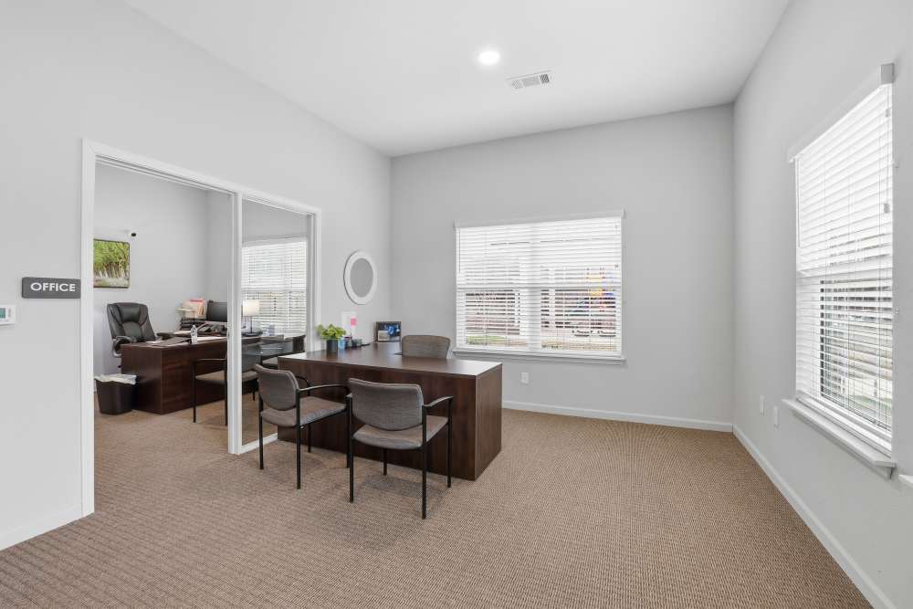 Bright and modern office space featuring a spacious desk and large windows, perfect for productivity at Flats At Sam Lane in Ringgold, Georgia.