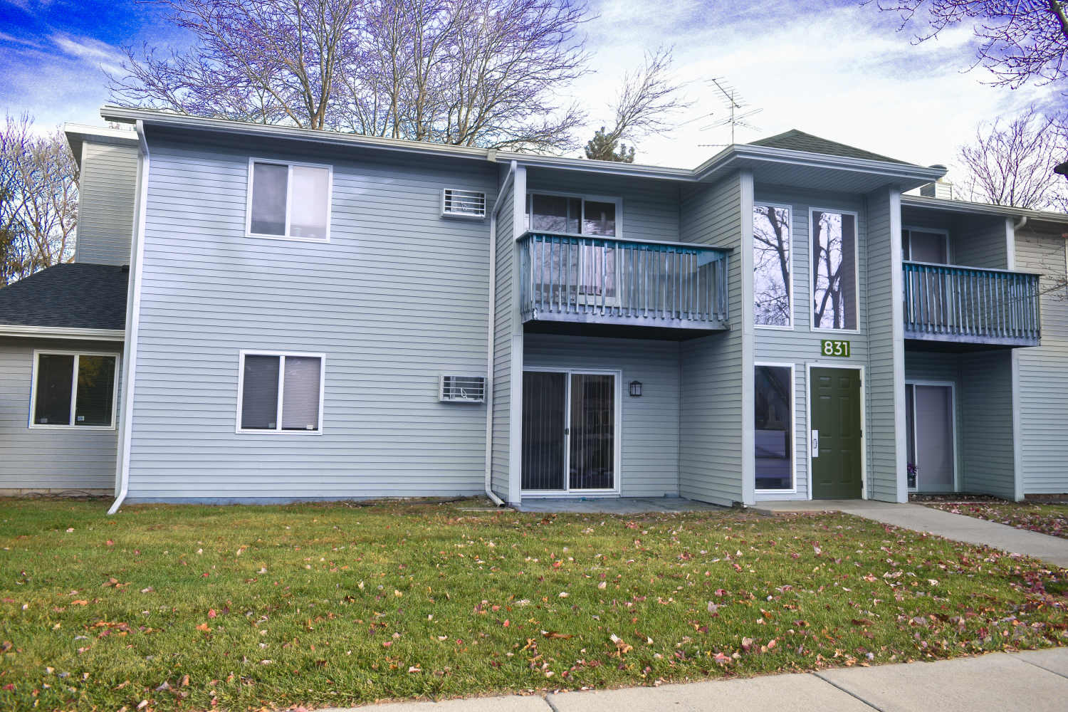 Exterior of the apartment building with a lawn in the front at Lakewood Apartments in Stockbridge, Michigan