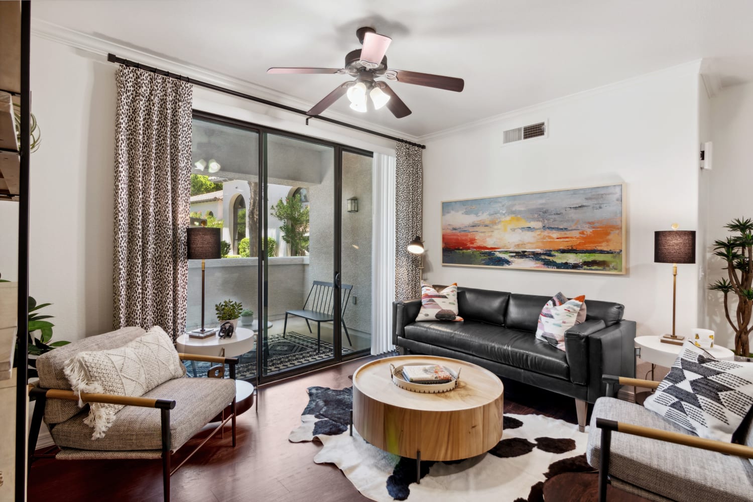 Well appointed living room with blue couch and wooden table at San Marquis in Tempe, Arizona