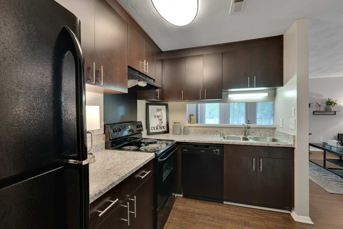 Kitchen with wooden cabinetry and energy-efficient appliances at Lake Lynn Reserve Apartments, Raleigh, North Carolina