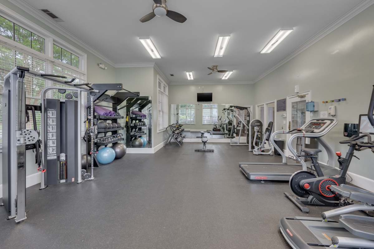 Fully-equipped fitness center with flat screen television and large windows at Kildaire Reserve Apartments in Cary, North Carolina