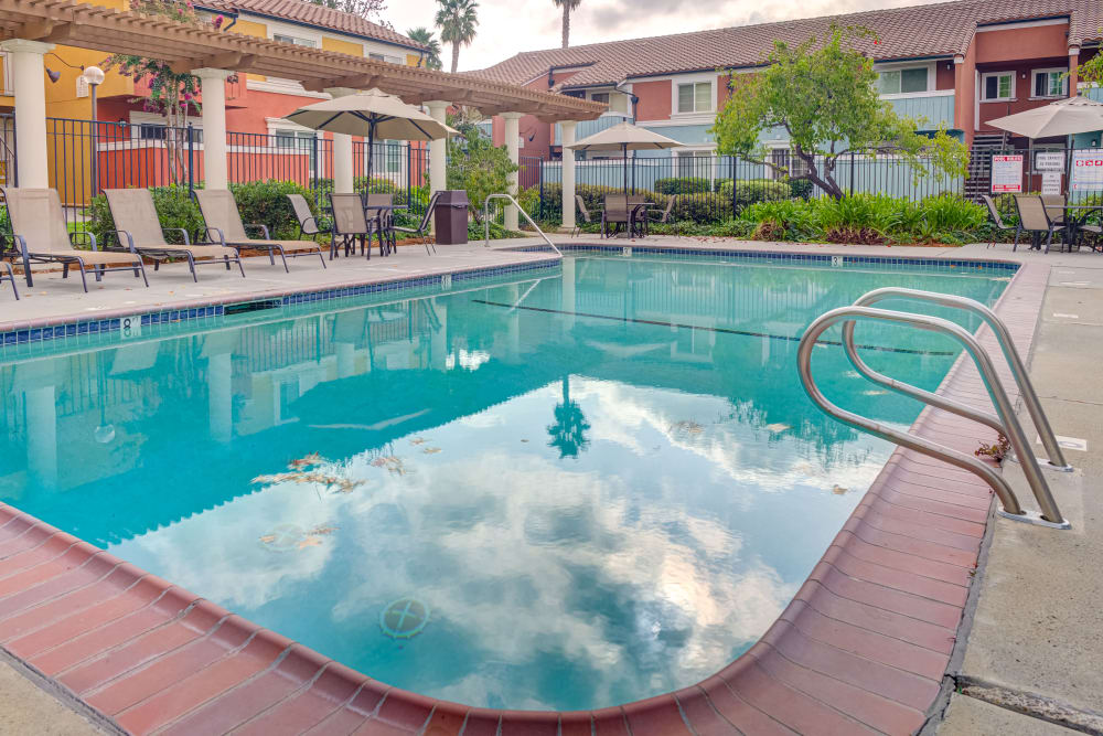 Chaise lounge chairs by the pool at Peppertree Apartment Homes in San Jose, California