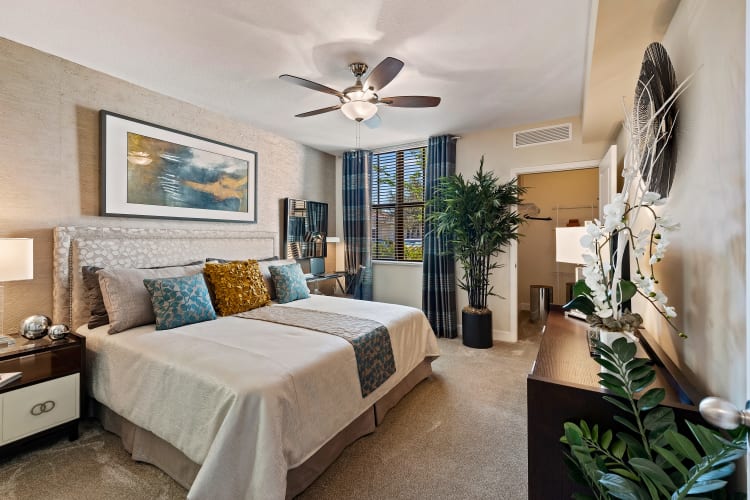 Carpeted model bedroom with a ceiling fan at The Residences at Lakehouse in Miami Lakes, Florida