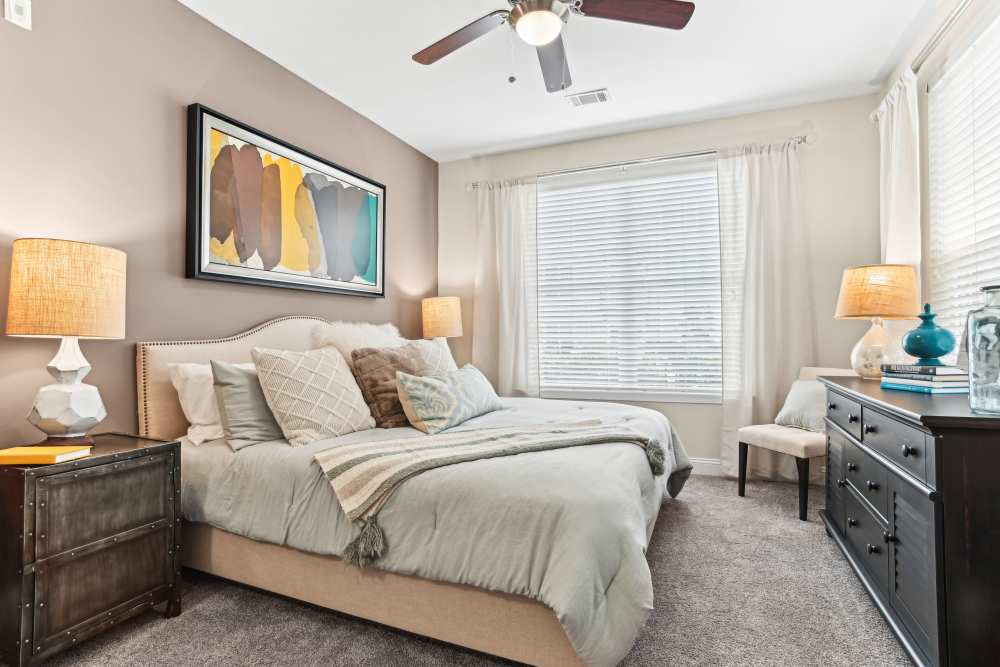 Apartment bedroom with ceiling fan at Fountains at Mooresville Town Square in Mooresville, North Carolina