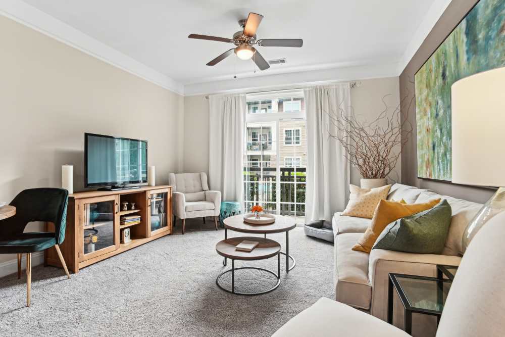 Modern apartment living area with ceiling fan at Fountains at Mooresville Town Square in Mooresville, North Carolina