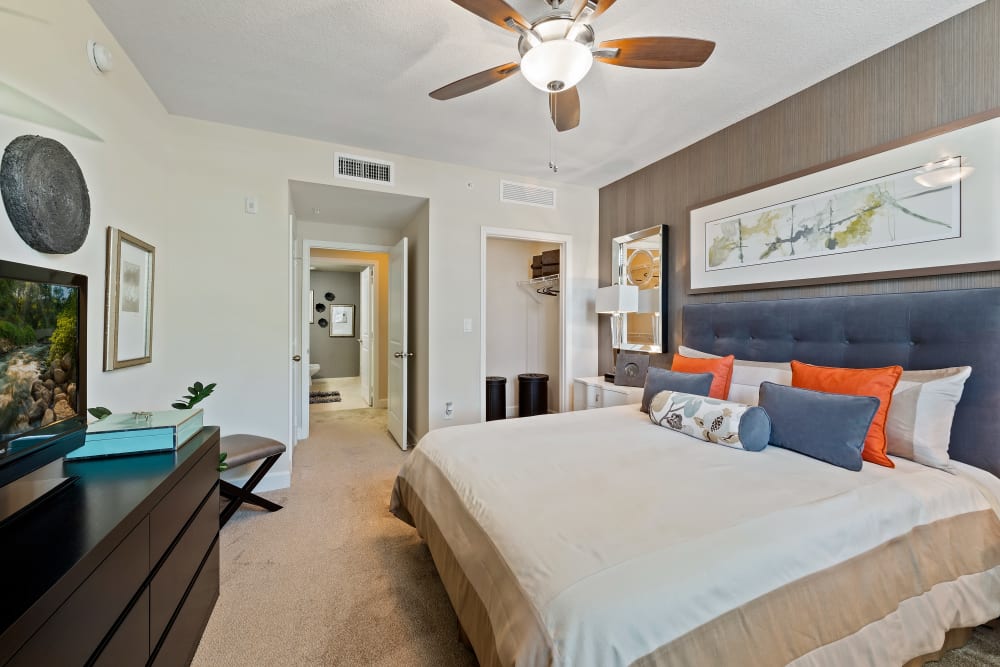 Model bedroom with ceiling fan and a walk-in closet at The Residences at Lakehouse in Miami Lakes, Florida