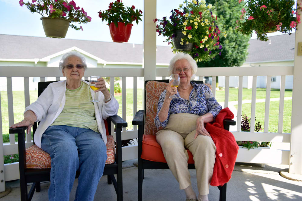 Two residents enjoying porch seating at Garden Place Columbia in Columbia, Illinois. 