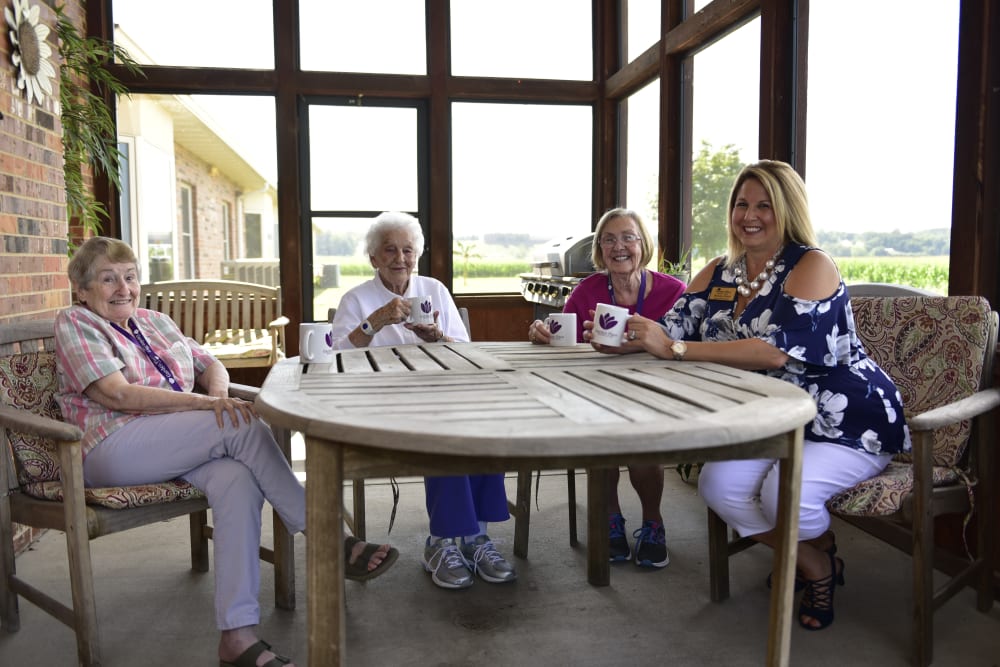 A group of residents and a caregiver enjoying a sun room at Garden Place Columbia in Columbia, Illinois. 