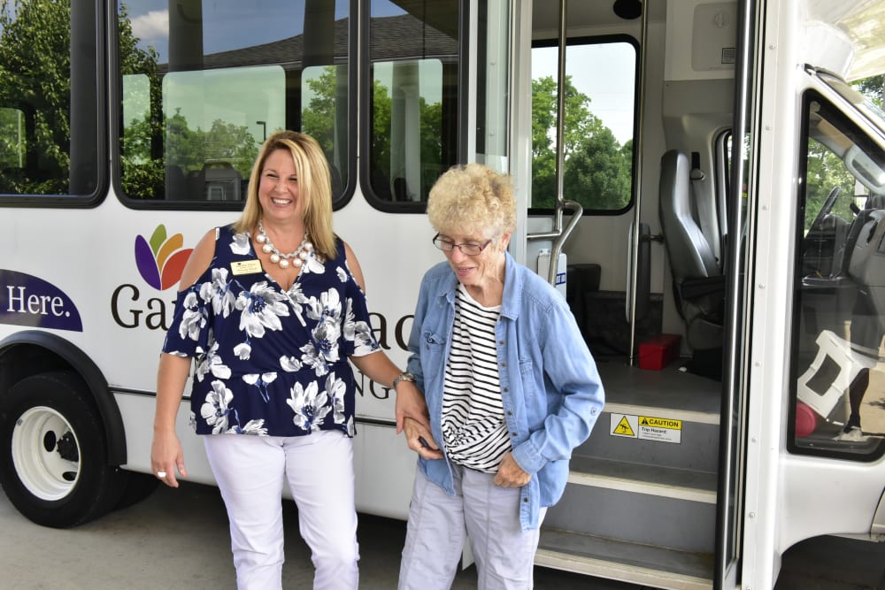 A resident  and caregiver in front of a transport vehicle at Garden Place Columbia in Columbia, Illinois. 