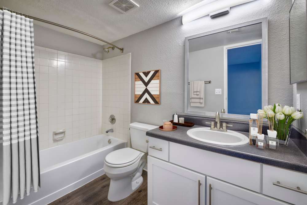Bathroom with a large mirror at Skyecrest Apartments in Lakewood, Colorado