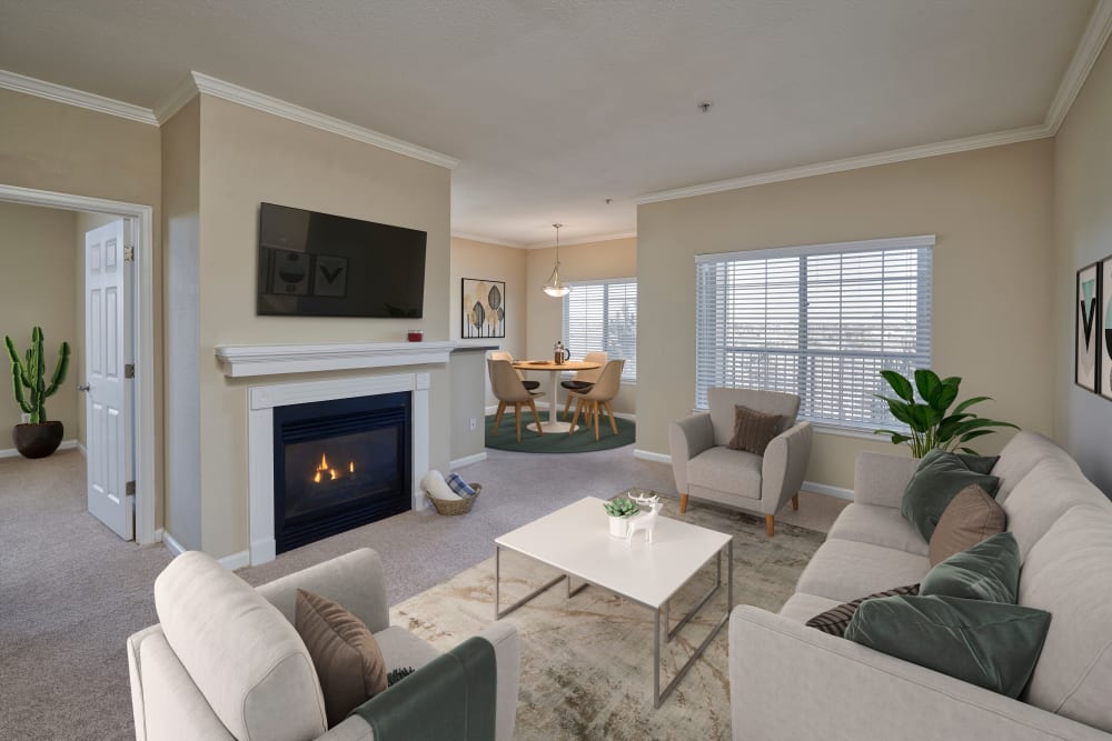 Living room and dining room with white accents and a fireplace at Skyecrest Apartments in Lakewood, Colorado