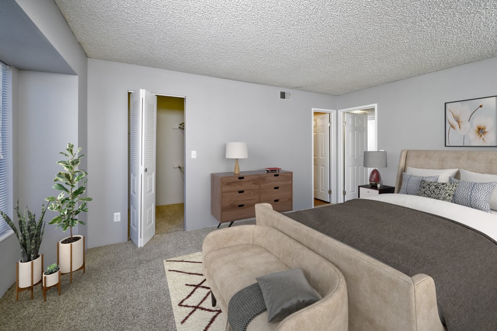 Decorated master bedroom with a large closet at Alton Green Apartments in Denver, Colorado