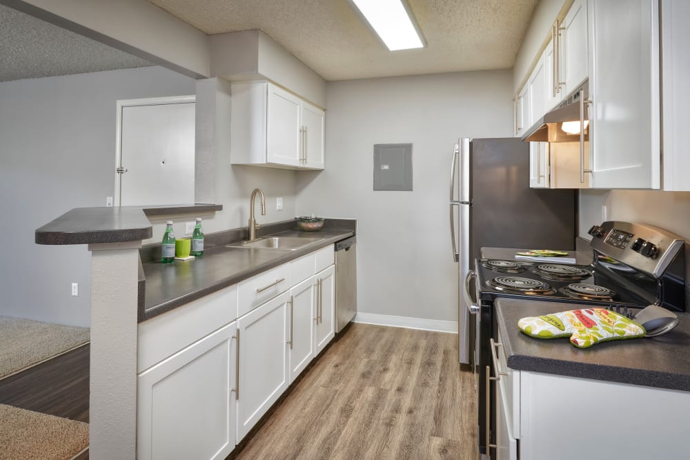 A kitchen with plenty of cabinet space at Alton Green Apartments in Denver, Colorado