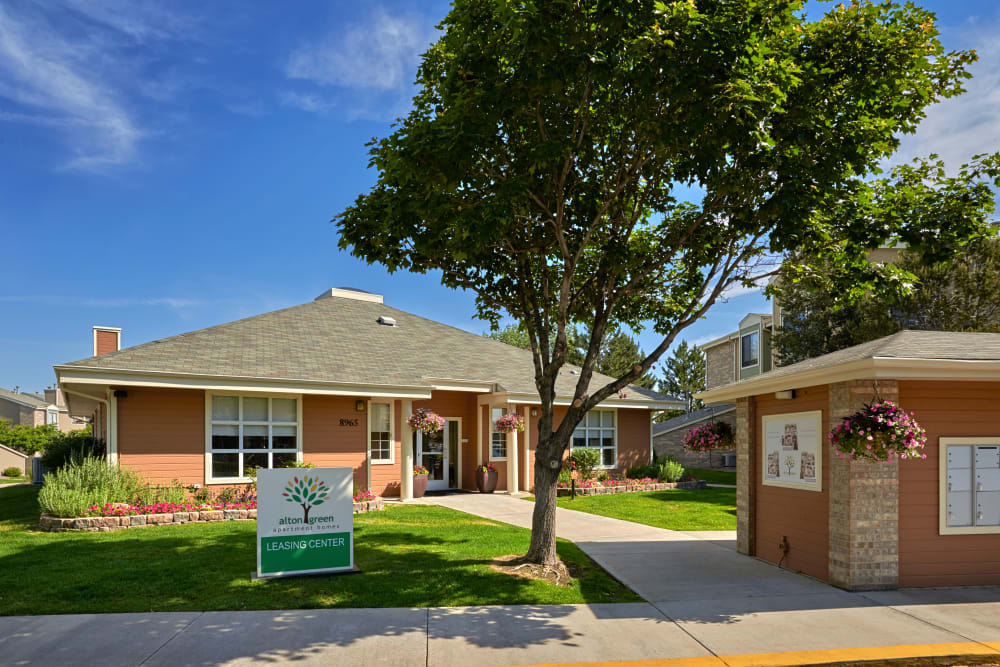 Leasing center entrance surrounded by a lush green landscape at Alton Green Apartments in Denver, Colorado
