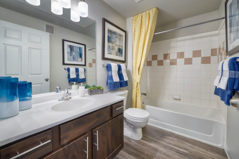 Renovated bathroom with brown cabinetry at Bear Valley Park in Denver, Colorado