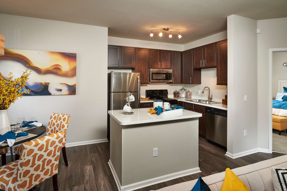 Dining room and kitchen with hardwood-style flooring at Bear Valley Park in Denver, Colorado