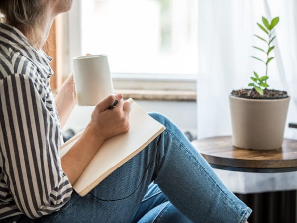 Resident writing in a notebook in her luxury home at K Street Flats Apartment Homes in Berkeley, California
