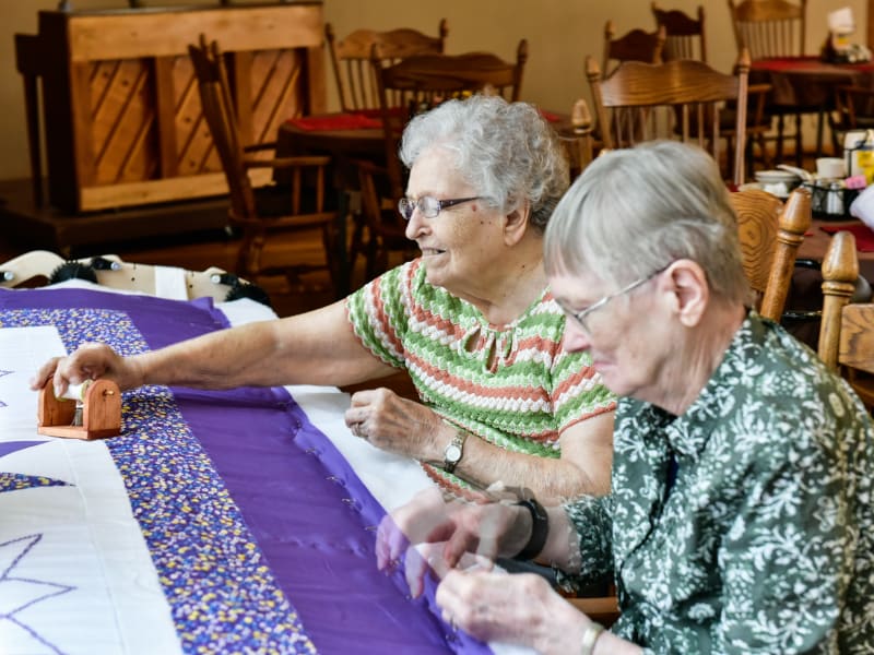 Two residents enjoying a sewing activity at Garden Place Red Bud in Red Bud, Illinois