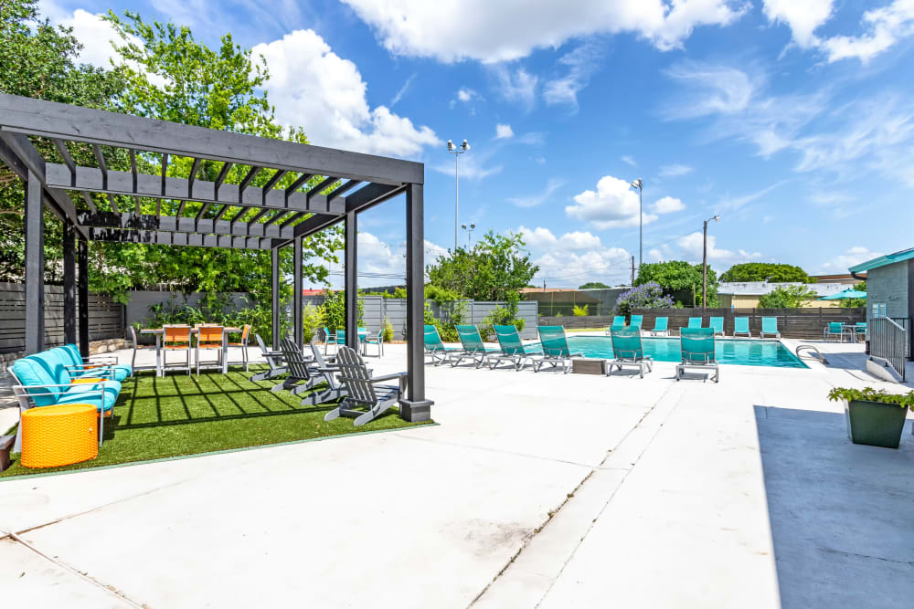 Pool deck and lounge chairs in a pavilion at EnVue Apartments in Bryan, Texas