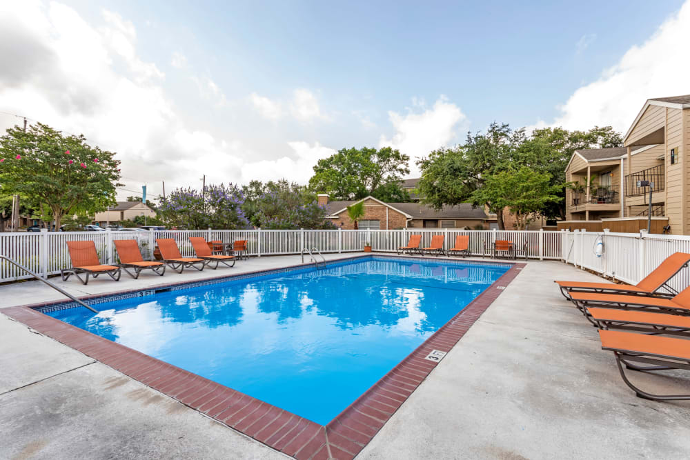Community pool and lounge chairs at Riverstone Apartments in Bryan, Texas