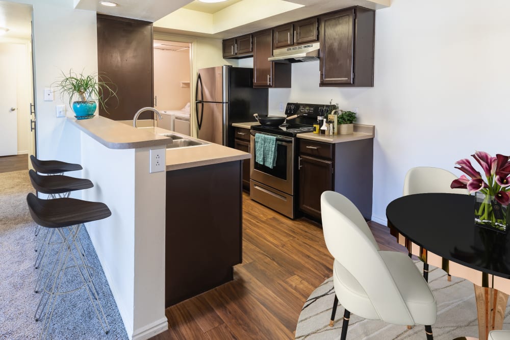 Kitchen with espresso cabinets and bar seating at Shadowbrook Apartments in West Valley City, Utah