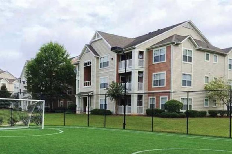 Exterior view of the buildings and soccer field at Belle Vista Apartment Homes in Lithonia, Georgia