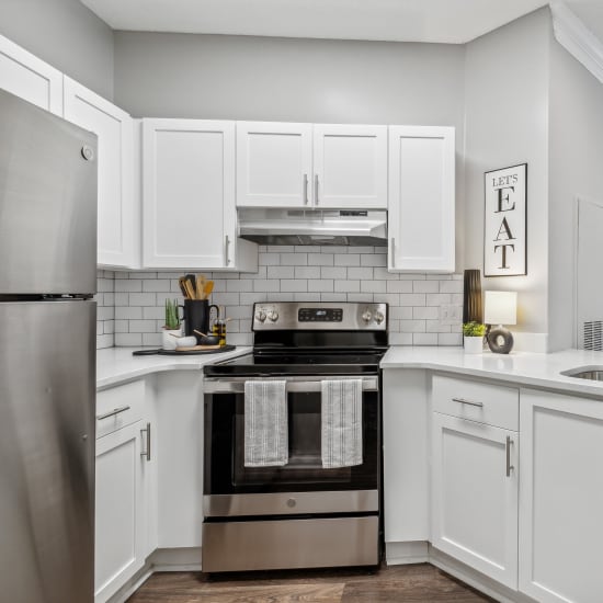 Kitchen with white Shaker-style cabinetry and stainless-steel appliances at Hawthorne Gates in Atlanta, Georgia