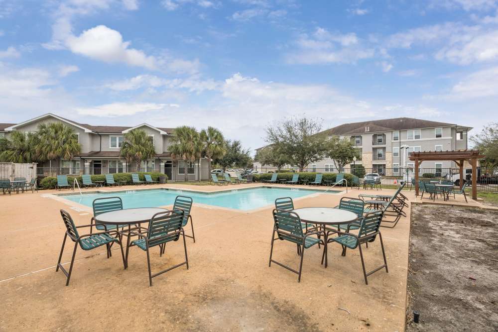 Resort style swimming pool with lounge seating at The Cove at Palmer Point in Texas City, Texas