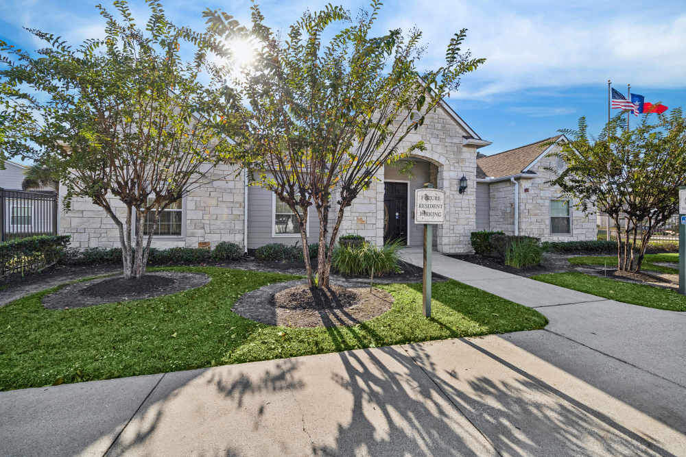 Charming entrance with lush landscaping at Arbor Pines in Orange, Texas.
