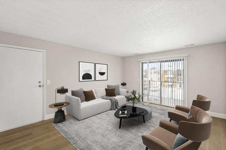Sunlit living room with modern decor and stylish seating at The Grove in Battle Creek, Michigan