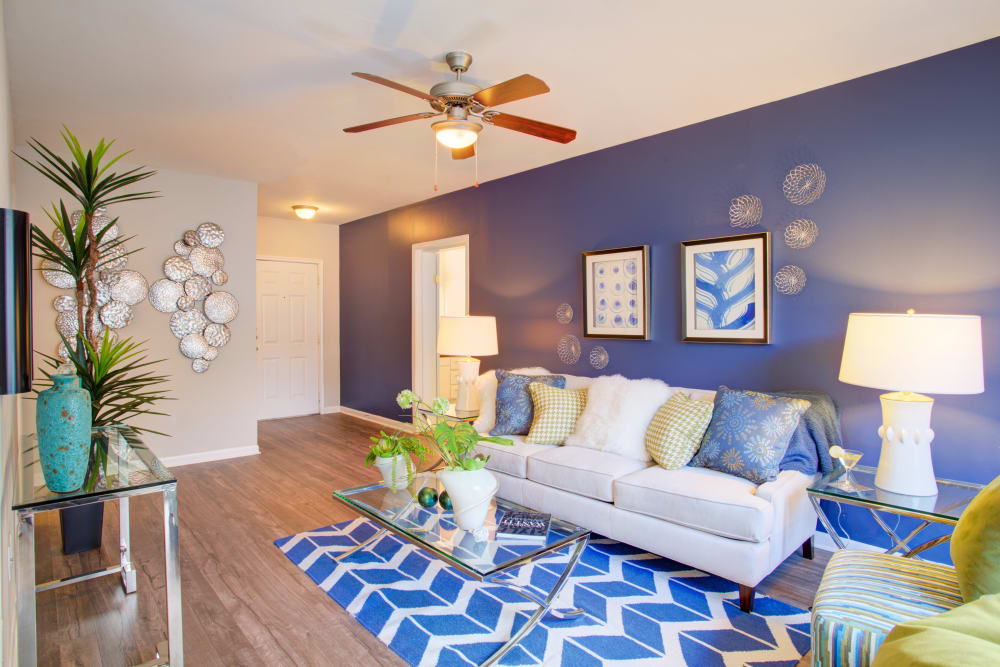 Model living room with ceiling fan and accent wall at Metro 5514 in Houston, Texas
