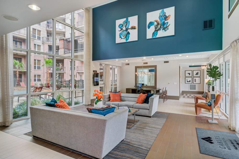 Bright and inviting lounge area at featuring modern decor and expansive windows that illuminate the charming space at Hollings Post Oak in Houston, Texas