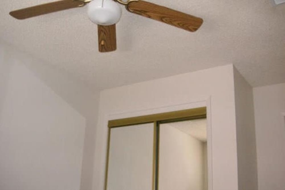 Bedroom with ceiling fan at Olympus Court Apartments in Bakersfield, California