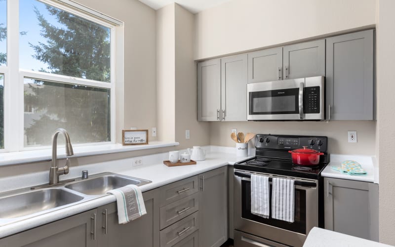 Renovated kitchen with trendy gray cabinets at HighGrove Apartments in Everett, Washington