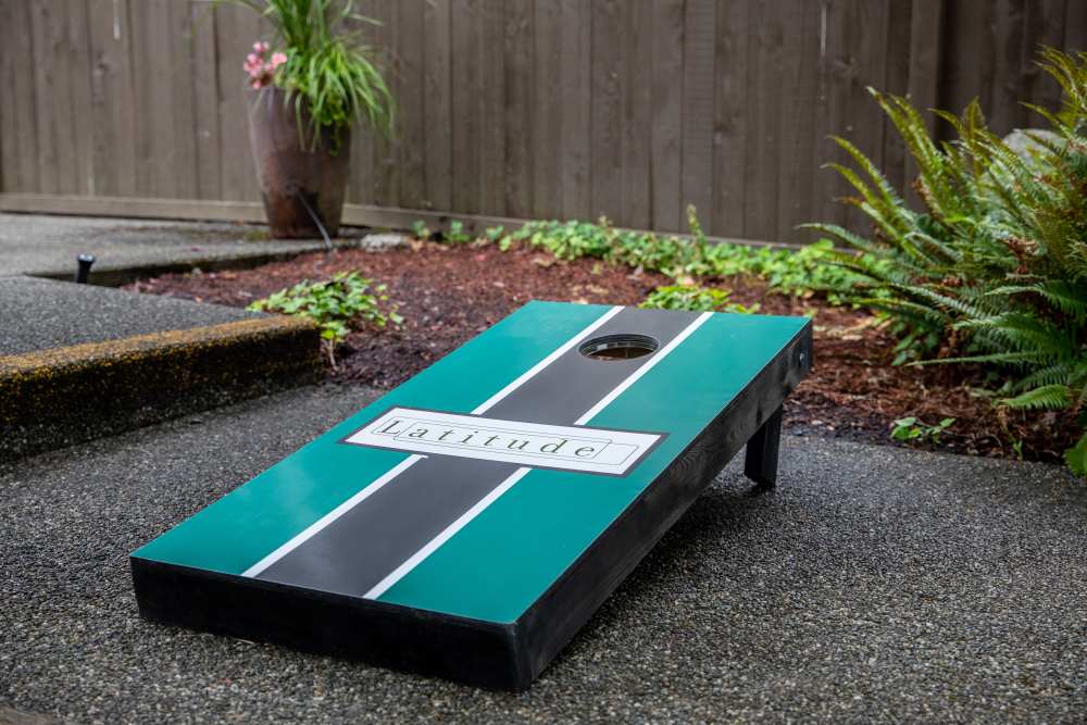 Corn hole board in common area courtyard at Latitude Apartments in Everett, Washington