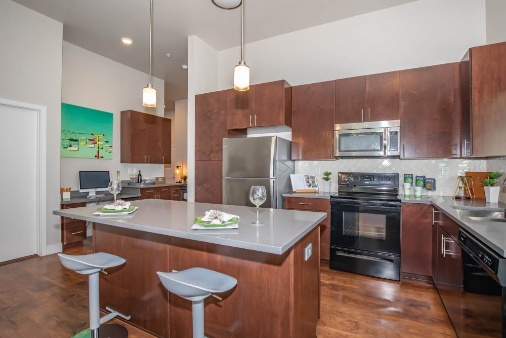Modern kitchen with island countertop and barstool at Park Place Olde Town Apartments in Arvada, Colorado