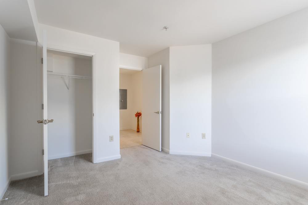 Bedroom with carpet flooring and closet at Corrigan Square Apartments in Gaithersburg, Maryland