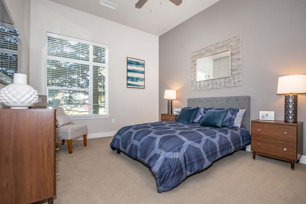 Spacious bedroom with king size bed, side table lamp and ceiling fan at Park Place Olde Town Apartments in Arvada, Colorado