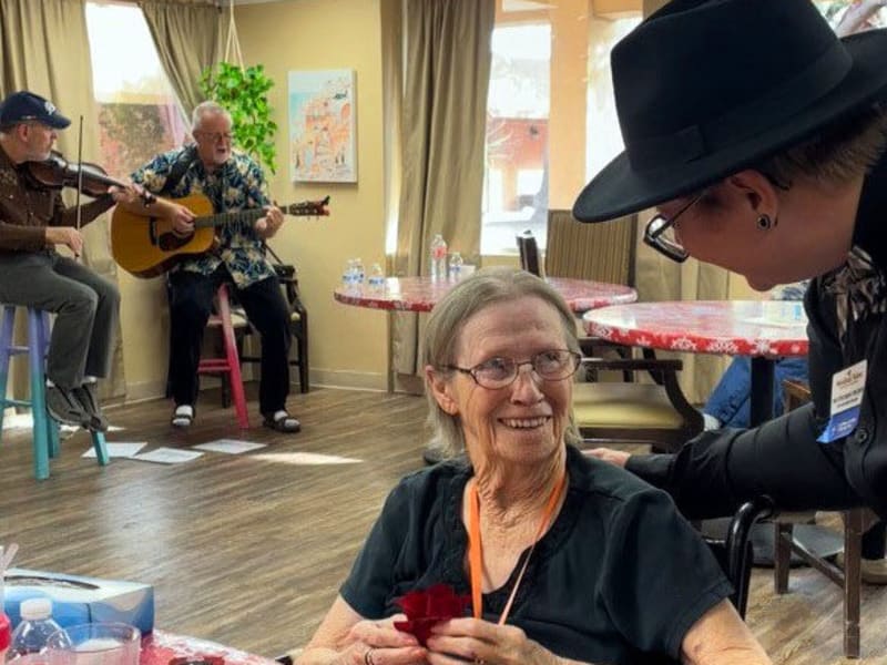Happy resident and 2 elderly musicians in the background at {location_name}} in Tucson, Arizona