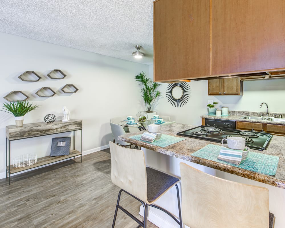 Beautiful hardwood flooring and granite countertops in the kitchen and dining areas of a model home at Sofi Poway in Poway, California