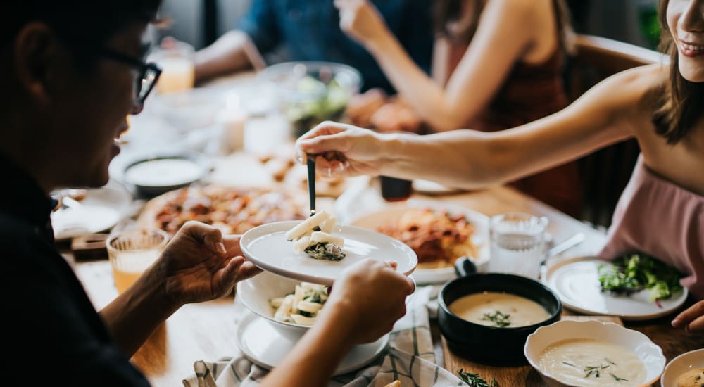 A group of people sharing food in a restaurant near Heritage at Riverstone in Canton, Georgia