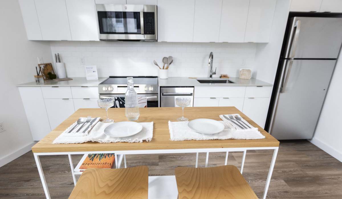 Dining area with kitchen island and modern cabinetry at Brookland Apartments in Portland, Oregon